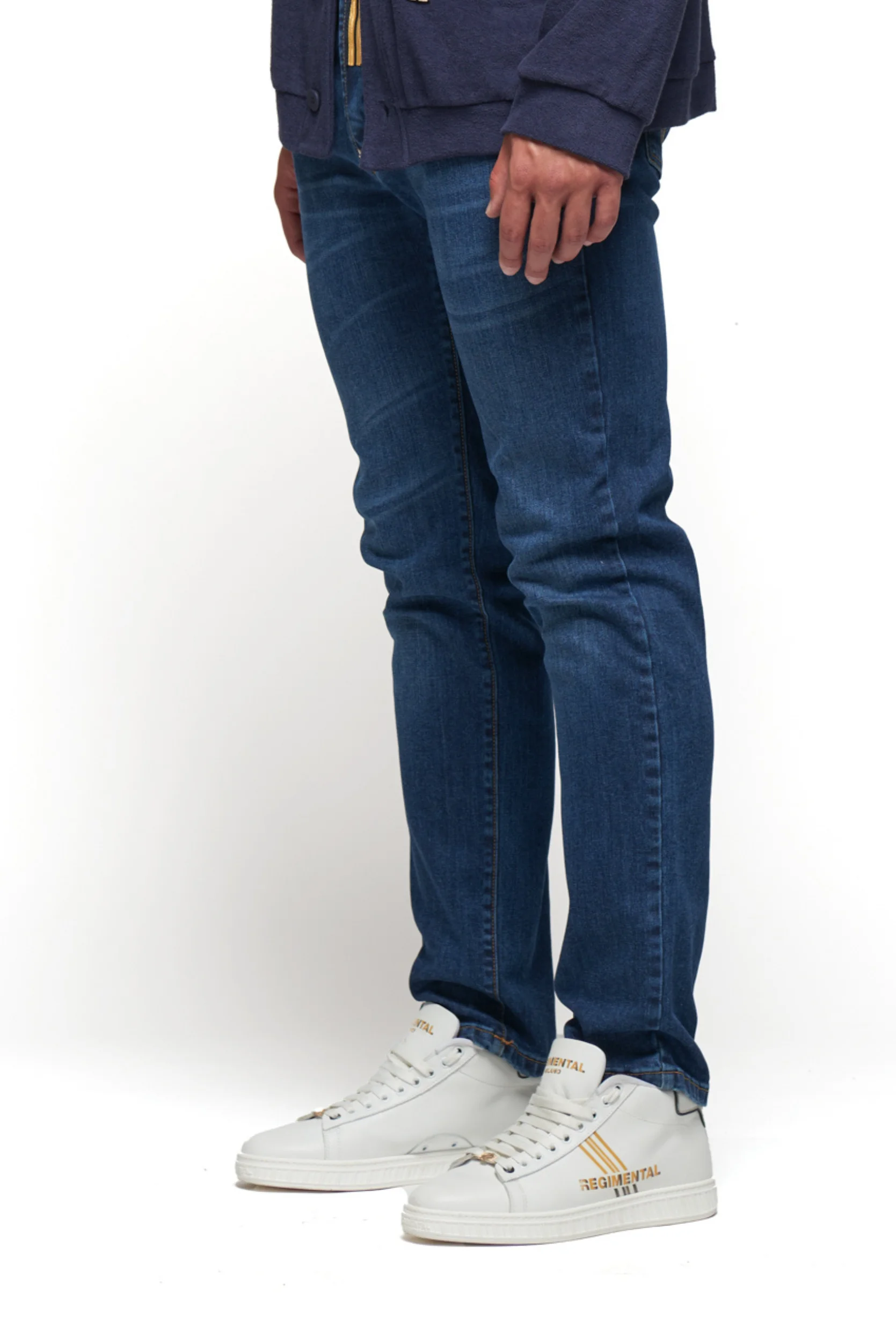 Persona con jeans Regimental Milano regular indigo ocean, vestibilità regolare e stile urbano, dettaglio frontale con gallone simbolico